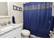 Well-maintained bathroom featuring a blue shower curtain and modern fixtures at 8642 Mallard Reserve Dr # 203, Tampa, FL 33614