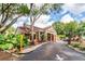Inviting clubhouse entrance with elegant brickwork, palm trees, and well-manicured landscaping creates a welcoming vibe at 8642 Mallard Reserve Dr # 203, Tampa, FL 33614