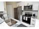 Modern kitchen featuring stainless steel appliances, white cabinets, and granite countertops at 8642 Mallard Reserve Dr # 203, Tampa, FL 33614