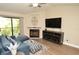 Living room features a ceiling fan, decorative fireplace, a large-screen TV, and plenty of natural light at 8642 Mallard Reserve Dr # 203, Tampa, FL 33614