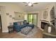 Cozy living room features a comfortable blue sectional, decorative fireplace, and sliding door to outside at 8642 Mallard Reserve Dr # 203, Tampa, FL 33614