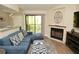 Comfortable living room with a blue sectional sofa, decorative fireplace, and access to the outdoor balcony at 8642 Mallard Reserve Dr # 203, Tampa, FL 33614