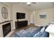Open living room featuring a fireplace, TV, blue sectional sofa, and plenty of space for relaxing at 8642 Mallard Reserve Dr # 203, Tampa, FL 33614