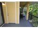 Covered porch featuring neutral yellow siding, black metal railing, and gray wood decking at 8642 Mallard Reserve Dr # 203, Tampa, FL 33614