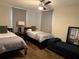 Cozy bedroom with twin beds, wood floors, and soft, neutral decor at 907 Fruitland Ave, Bradenton, FL 34207