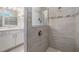 Modern tiled shower in bathroom with glass partition and updated fixtures, adjacent to the vanity at 9588 Ibis Grove Blvd, Wesley Chapel, FL 33545