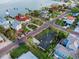 Breathtaking aerial perspective showcasing a coastal neighborhood with waterfront homes and lush greenery at 100 Buena Vista S Dr, Dunedin, FL 34698