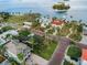 Wide aerial perspective of coastal homes nestled among swaying palm trees and overlooking the serene bay at 100 Buena Vista S Dr, Dunedin, FL 34698
