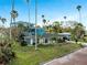 Charming single-story home featuring large windows, a well-kept lawn, and mature palms at 100 Buena Vista S Dr, Dunedin, FL 34698