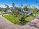 Captivating exterior showcasing a cozy home with manicured lawn and swaying palms on a unique brick street at 100 Buena Vista S Dr, Dunedin, FL 34698