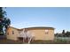 Exterior view of the home, featuring a backyard with a deck and lush green grass at 1136 Forbes Trce, Tarpon Springs, FL 34689