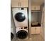 Convenient laundry room featuring a stacked washer and dryer and overhead cabinets at 1149 6Th Ne Ave, Largo, FL 33770