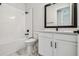 Modern bathroom with white subway tile, bathtub, and elegant vanity with a black faucet at 11842 Richmond Trl, Parrish, FL 34219
