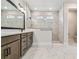 A luxurious bathroom showcasing marble tile flooring, modern vanity, and a sleek glass-enclosed shower at 11842 Richmond Trl, Parrish, FL 34219