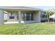 View of covered patio with sliding glass doors and grassy backyard at 11842 Richmond Trl, Parrish, FL 34219
