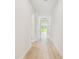 Bright hallway with wood floors and natural light at end at 11842 Richmond Trl, Parrish, FL 34219