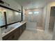 Modern main bathroom with double sinks, a large mirror, and a walk-in shower at 11842 Richmond Trl, Parrish, FL 34219
