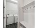 Functional mud room area with coat hooks, bench, and a glimpse into the laundry area at 11842 Richmond Trl, Parrish, FL 34219