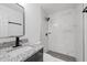 Modern bathroom with a black framed mirror, gray vanity, and stylish black and white tiled shower for a spa-like retreat at 11860 129Th Ave, Largo, FL 33778