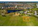 Aerial view of a playground, baseball diamond, parking, and beautiful pond surrounded by single Gathering homes at 12031 Medley Ter, Lakewood Ranch, FL 34211
