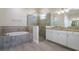 Bathroom features soaking tub, glass shower, double vanity, and modern lighting at 12031 Medley Ter, Lakewood Ranch, FL 34211