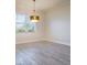 Dining room with wood-look tile flooring and modern light fixture at 12031 Medley Ter, Lakewood Ranch, FL 34211