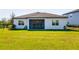 Wide angle view of the back of the home with green lawn and covered lanai at 12031 Medley Ter, Lakewood Ranch, FL 34211