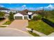 Aerial shot of a charming home featuring a two-car garage, brick driveway, manicured landscaping and stone detailing at 12031 Medley Ter, Lakewood Ranch, FL 34211
