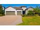 Charming home featuring a two-car garage, brick driveway, well-manicured landscaping and stone detailing at 12031 Medley Ter, Lakewood Ranch, FL 34211