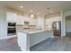 Modern kitchen featuring white cabinets, stainless steel appliances, granite counters and a large center island at 12031 Medley Ter, Lakewood Ranch, FL 34211