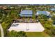The volleyball court is in front of a stunning clubhouse with meticulously landscaped surroundings and tall palm trees at 12031 Medley Ter, Lakewood Ranch, FL 34211