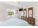 Bright bedroom with ceiling fan, a large window, and a stylish wooden dresser with mirrors at 12760 Indian Rocks Rd # 532, Largo, FL 33774