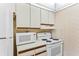 Cozy kitchen with white appliances, a microwave, and patterned wallpaper at 12760 Indian Rocks Rd # 532, Largo, FL 33774