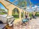 Outdoor living space with grill, seating area, and view to the beautiful surroundings at 13148 Huntington Woods Ave, Spring Hill, FL 34609