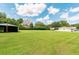 Property featuring a large green lawn, outbuildings, and a home in the background at 1700 S Miller Rd, Valrico, FL 33594