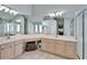 Bright bathroom featuring dual sinks, vanity, a large mirror and walk-in shower at 18507 Country Crest Pl, Tampa, FL 33647