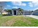 Charming home featuring a well-manicured lawn, complemented by lush landscaping and elegant architectural details at 18507 Country Crest Pl, Tampa, FL 33647