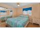 Bright bedroom with a ceiling fan, mirrored closet doors, and a side table at 196 Philadelphia Blvd # 10, Palm Harbor, FL 34684