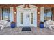 Charming brick building entrance featuring a decorative door, potted plants and cozy benches at 196 Philadelphia Blvd # 10, Palm Harbor, FL 34684