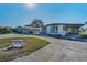 Well-kept single-story home with covered parking, ramp, and a decorative bench in the front yard at 196 Philadelphia Blvd # 10, Palm Harbor, FL 34684