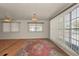Bright living room with wood-look floors, large windows and elegant chandelier at 196 Philadelphia Blvd # 10, Palm Harbor, FL 34684