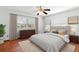 A staged bedroom with warm hardwood floors, neutral walls, and a large picture window at 1974 Valencia Way, Clearwater, FL 33764