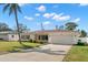 Charming single-story home featuring a well-manicured lawn, a long driveway, and an attached two-car garage at 1974 Valencia Way, Clearwater, FL 33764