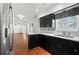 Stylish kitchen boasting black cabinets, stainless steel appliances, and terracotta tile flooring at 1974 Valencia Way, Clearwater, FL 33764