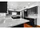 Modern kitchen featuring black cabinetry, stainless steel appliances, and white quartz countertops at 1974 Valencia Way, Clearwater, FL 33764