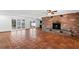 Spacious living room with terracotta tile flooring, a brick fireplace, and sliding glass doors that offer natural light at 1974 Valencia Way, Clearwater, FL 33764