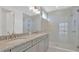 Bright bathroom featuring double vanity with granite counters and a glass-enclosed shower at 31869 Anchor Point Dr, Wesley Chapel, FL 33545