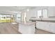Open-concept kitchen with large island, granite countertops, stainless steel appliances, and backyard views at 31869 Anchor Point Dr, Wesley Chapel, FL 33545
