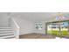 Bright living room featuring hardwood floors, modern lighting, and sliding glass doors to backyard at 31869 Anchor Point Dr, Wesley Chapel, FL 33545