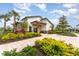 Beautiful clubhouse exterior featuring manicured landscaping, a brick walkway, and neutral color palette at 3231 Hilltop Cir, Bradenton, FL 34211